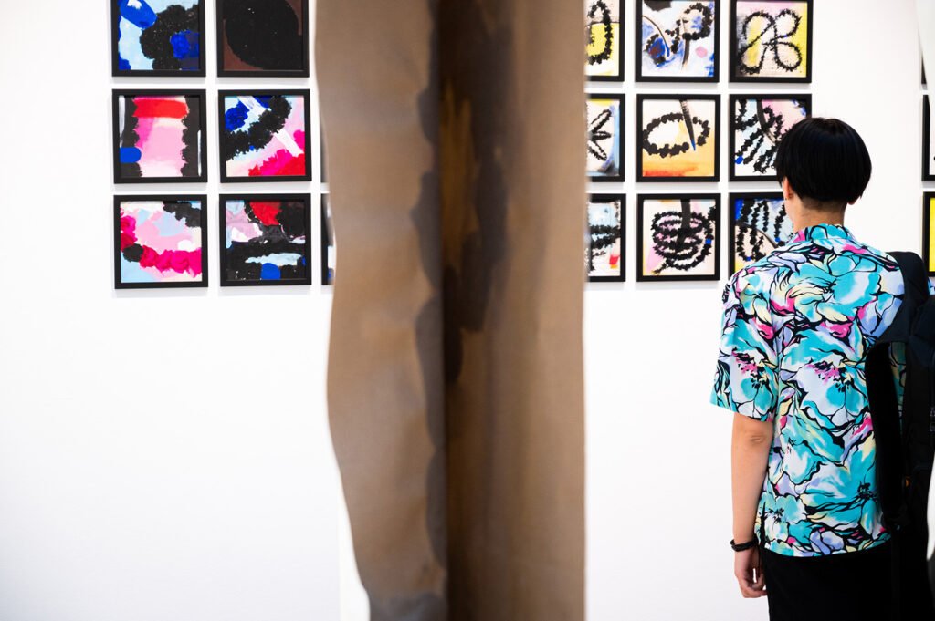 visitor-observing-vertical-canvases-and-modular-paintings-grid
