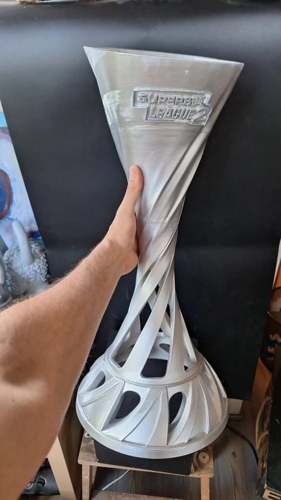 The Superbet League 2 trophy held by hand in the studio, July 2026